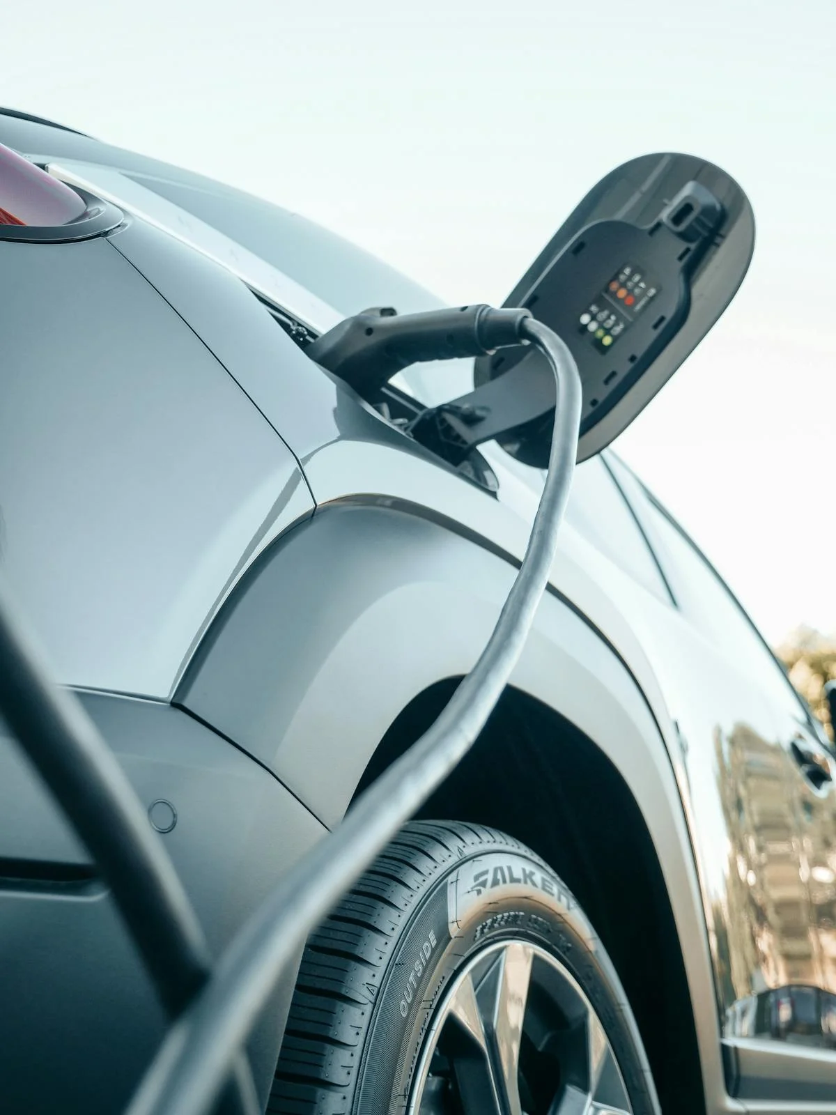 CCS connector plugged into electric vehicle at commercial charging station