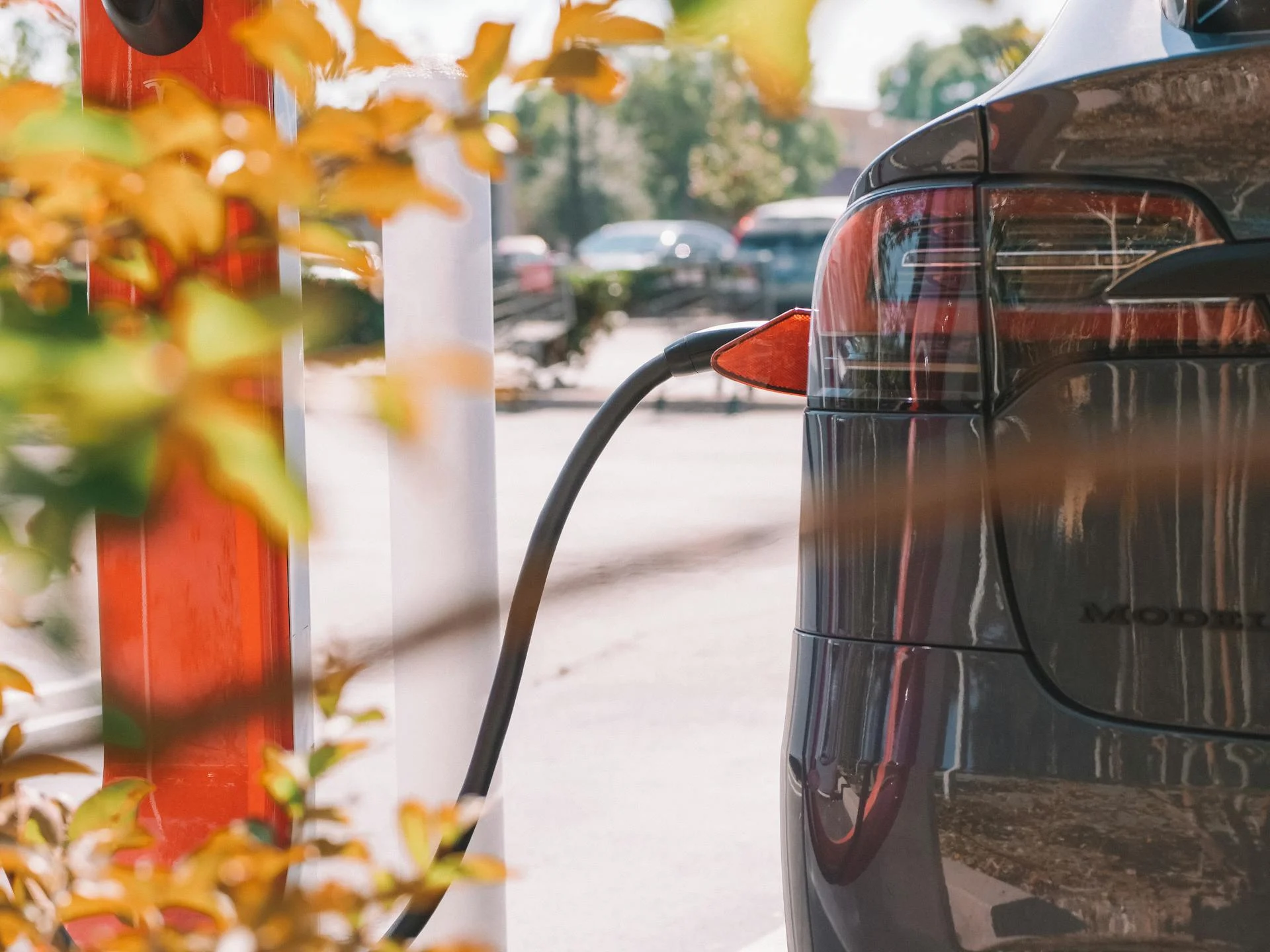 Electric car charging with blurred vehicles in background